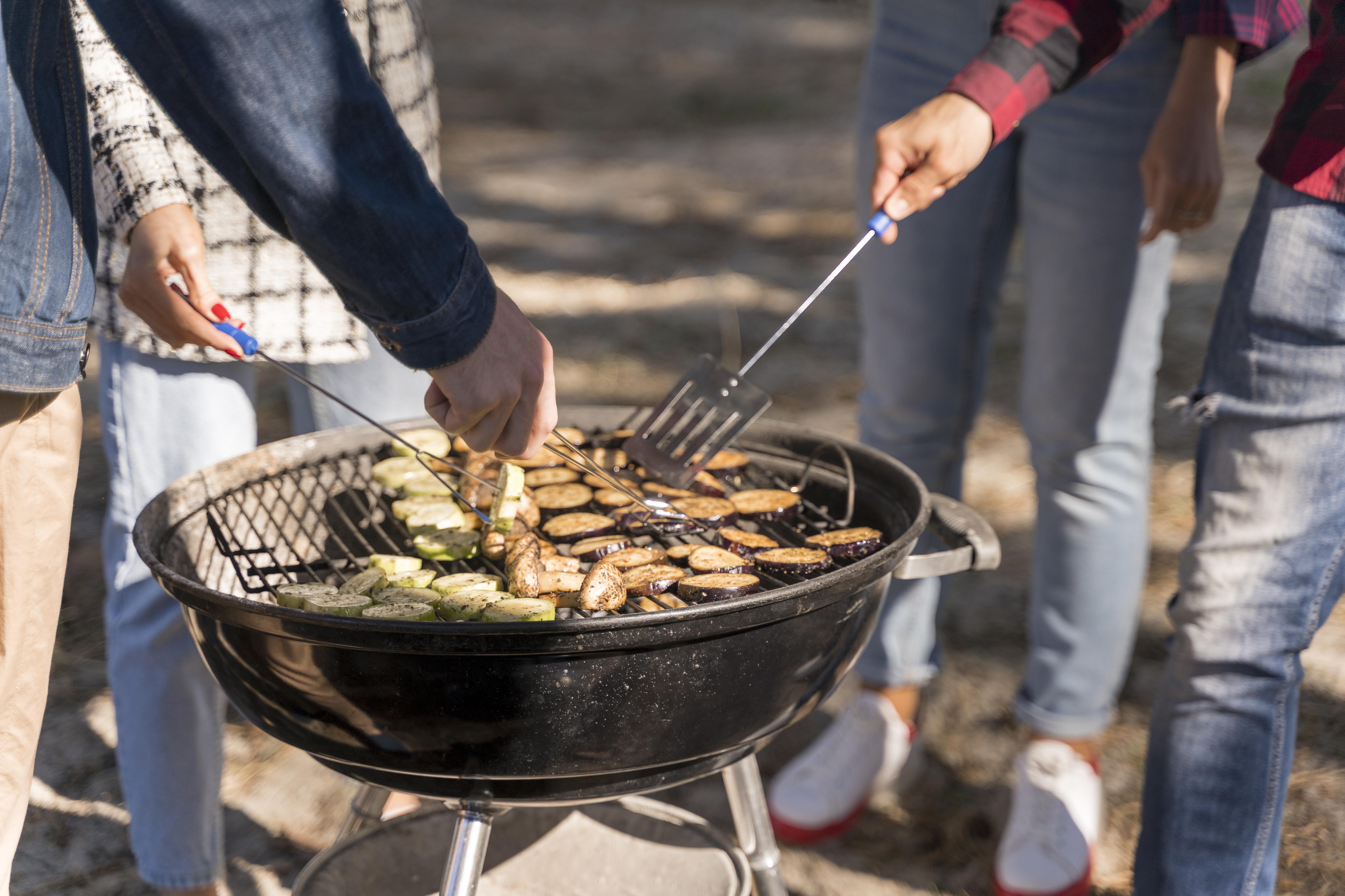 Ψησταριά BBQ κάρβουνου σε κήπο με παρέα που ψήνει κρέας